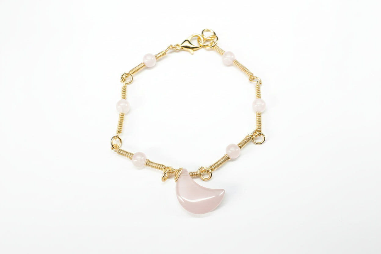 Copper Gold Plated bracelet with pink semi-precious stones on a light gray background